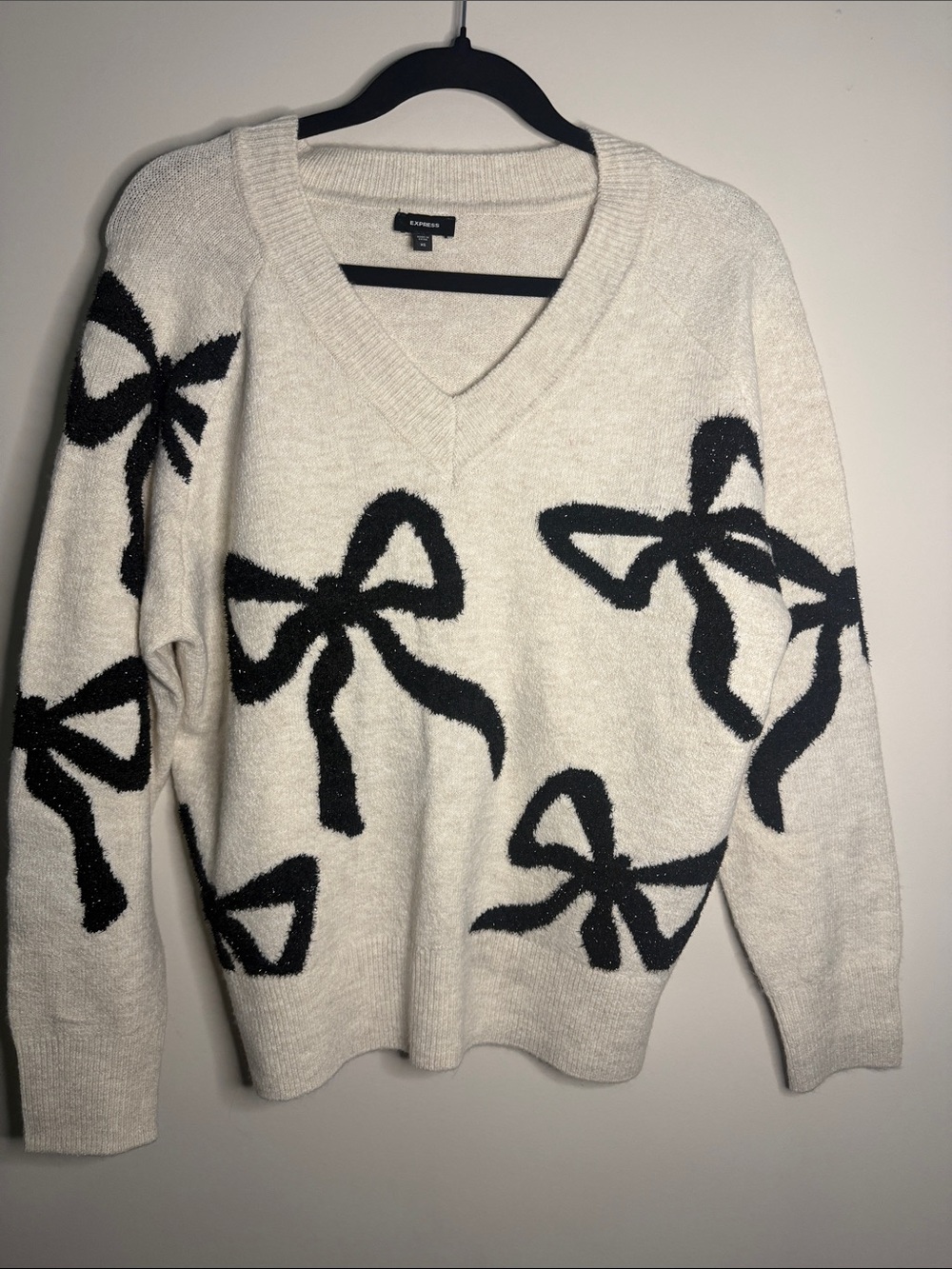 Express Cream V-Neck Sweater with Black Bow Design
